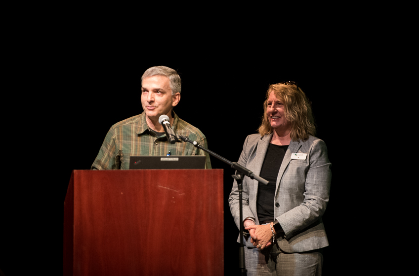 Two people standing at a podium on stage