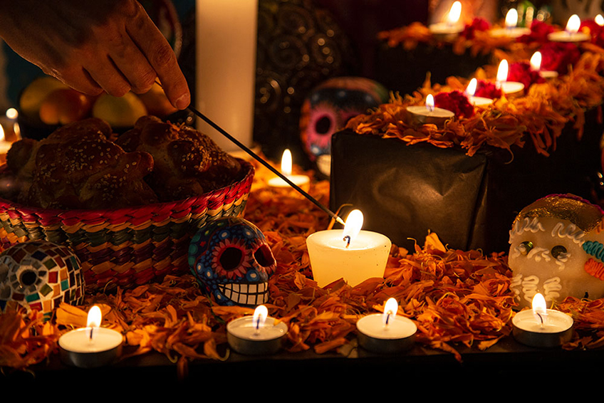 Candle being lit at Dia de los muertos altar.