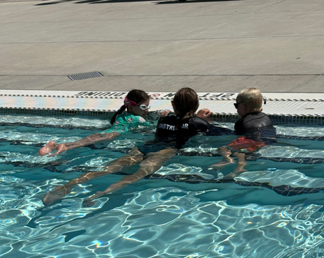 Swim instructor and two children in the pool