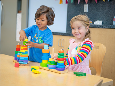 two children playing with colorful stacking rings